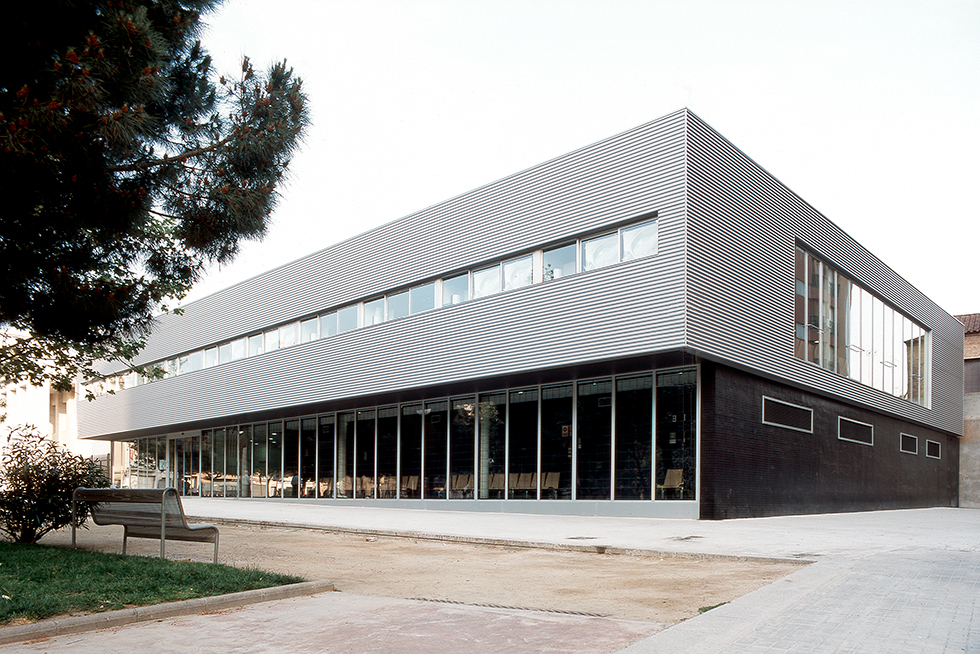 A modern medical clinic exterior featuring large windows and sleek, horizontal metal paneling.