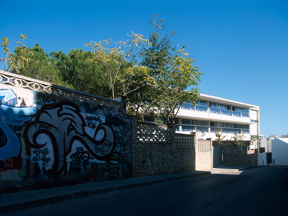 School building with a graffiti-decorated wall in the foreground.