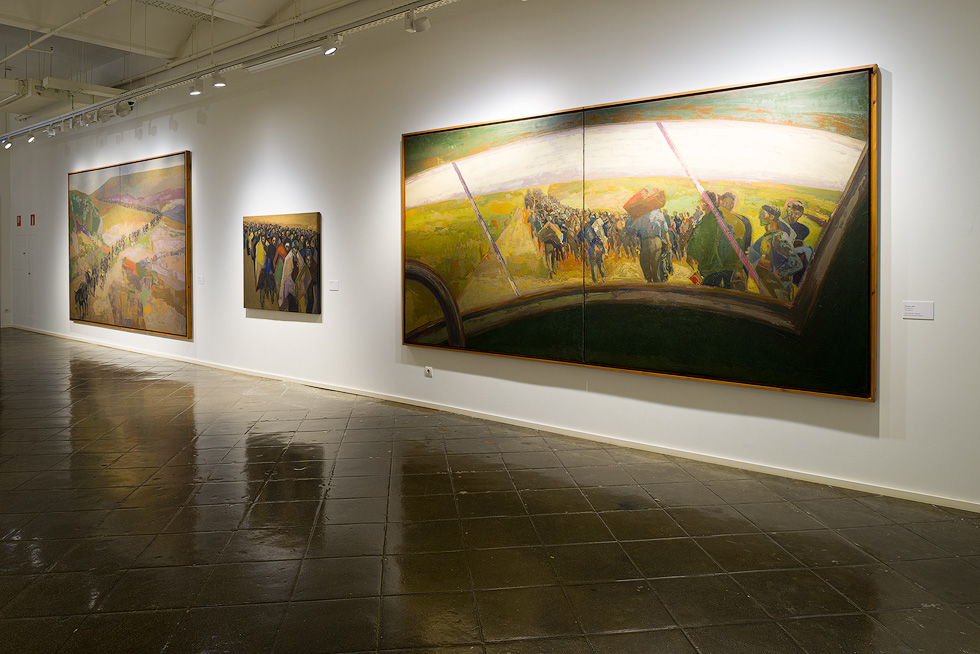 Large paintings depicting vibrant scenes of people and landscapes are displayed on the walls of a gallery.