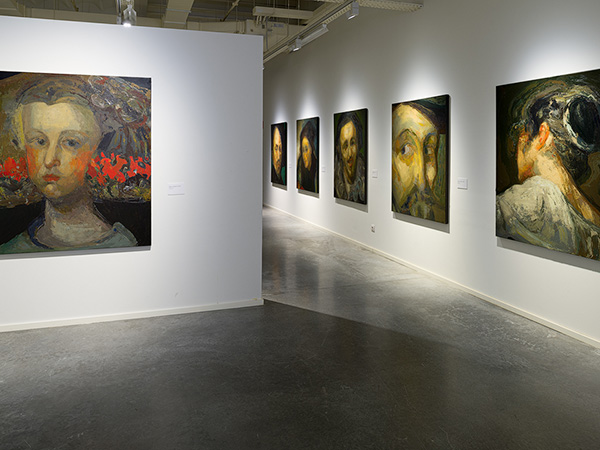 Art gallery with Guerrero Medina's portrait paintings on display, featuring a large portrait prominently on a white partition wall.