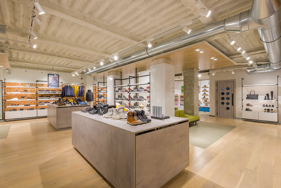 Interior of Geox store, showcasing a modern, well-lit space with shoes and jackets neatly displayed on shelves and tables.