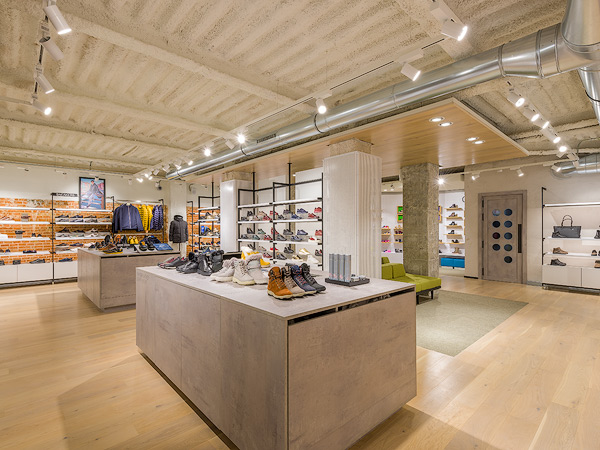 Interior of Geox store in Barcelona, showcasing a modern, well-lit space with shoes and jackets neatly displayed on shelves and tables.