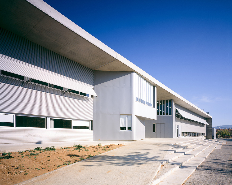 Modern architectural details of Fontajau High School, showcasing its sleek lines and large windows under a clear blue sky.