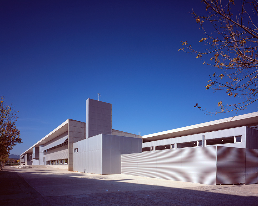 Exterior view showing a modern architectural design with clean lines and large windows under a clear blue sky.