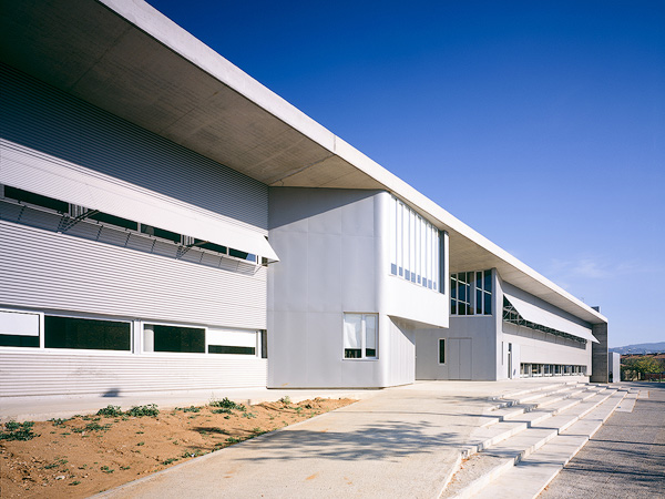 Modern architectural details of Fontajau High School, showcasing its sleek lines and large windows under a clear blue sky.