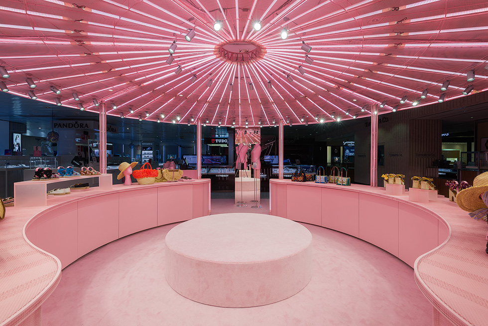 Central circular display area in Miu Miu's pink pop-up store with illuminated ceiling and merchandise.