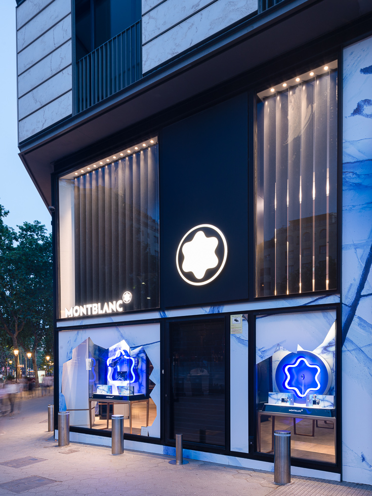 Night view of Montblanc store with glowing glacier-themed displays and the iconic Montblanc logo.