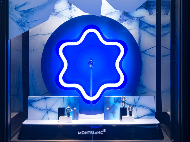 Exterior view of a Montblanc store with glacier-themed window displays and branding.