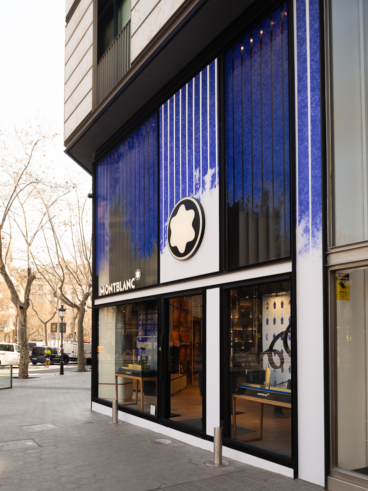 Montblanc store exterior during the day with blue artistic window design and Montblanc logo.