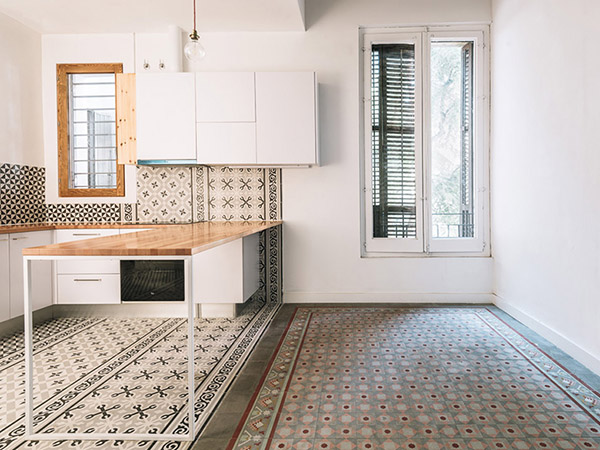 Modern kitchen with patterned tiles, wooden accents, and a minimalist work table.