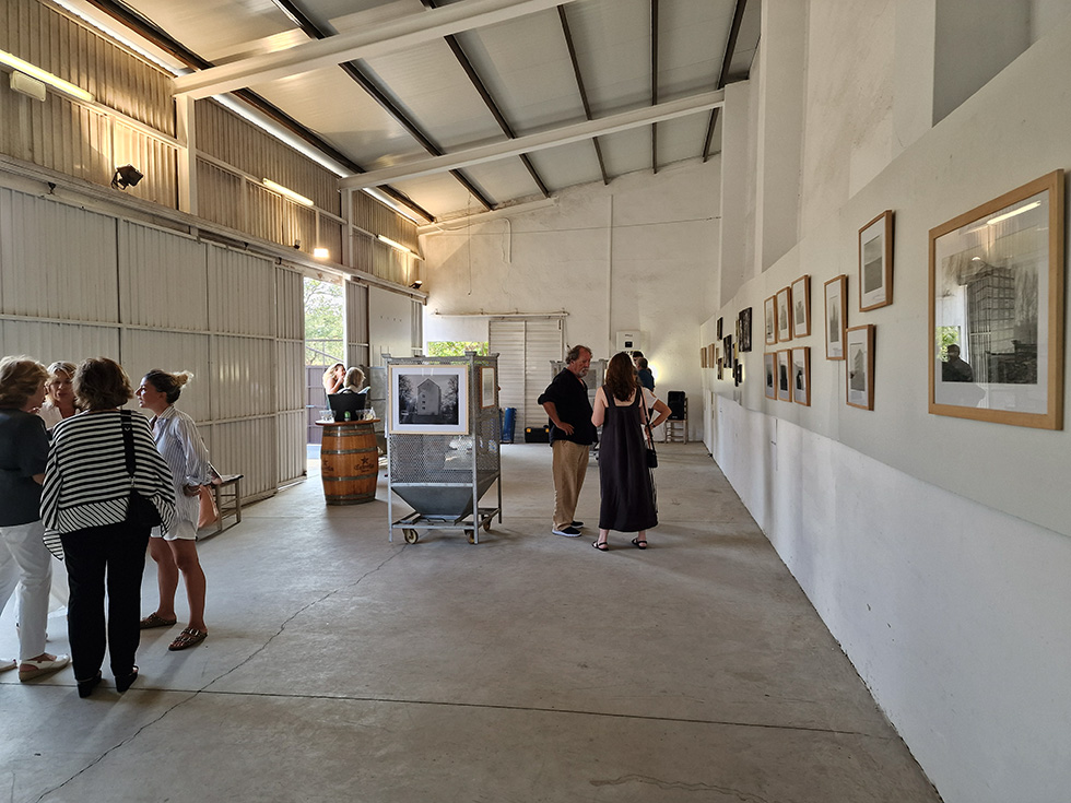 Visitors discussing artwork in a minimalist, industrial-style gallery.