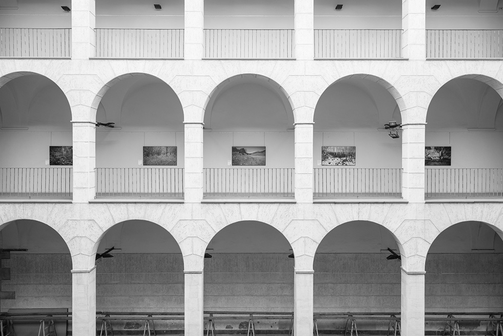 Arched gallery with displayed artworks on the upper level.