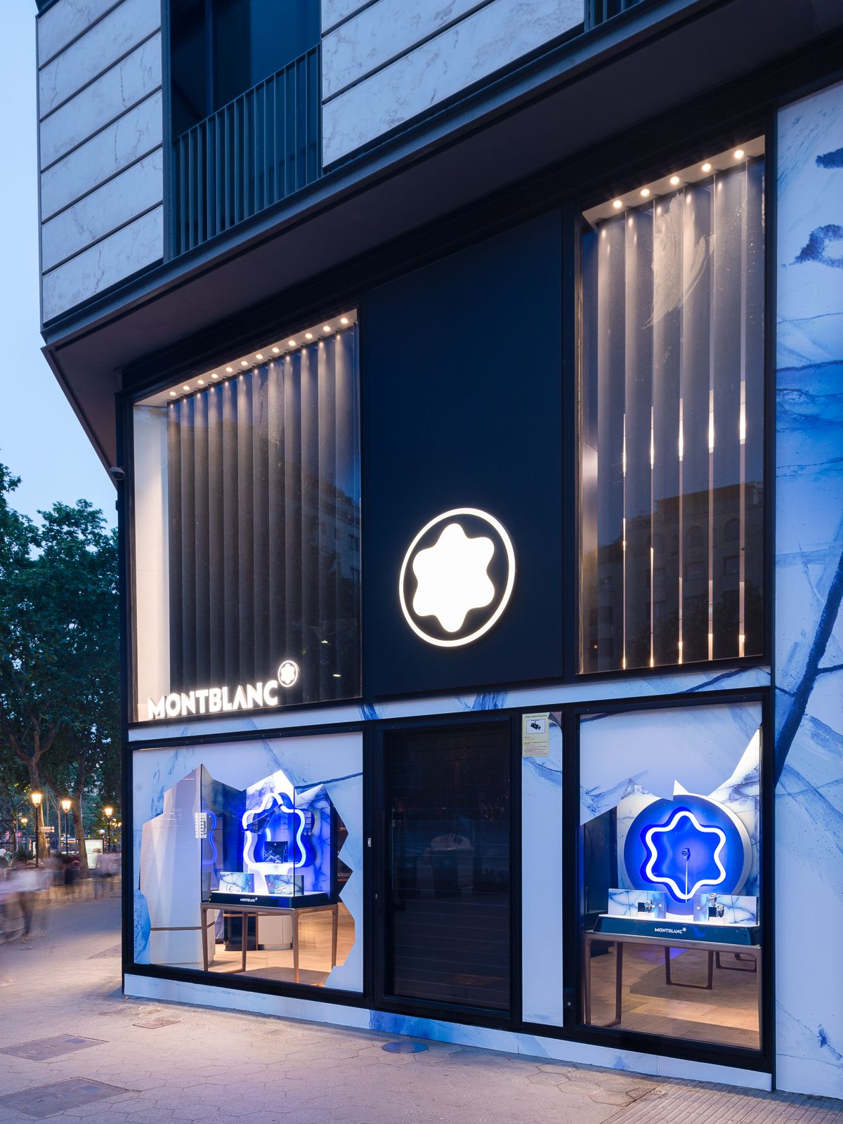 Night view of Montblanc store with glowing glacier-themed displays and the iconic Montblanc logo.