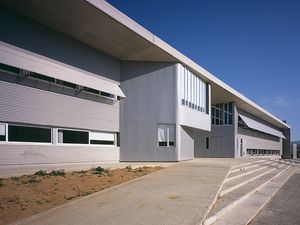 Detalles arquitectónicos modernos del Instituto Fontajau, mostrando sus líneas elegantes y grandes ventanas bajo un cielo azul despejado.