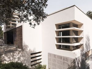 Exterior modern d'una casa amb grans finestres i una terrassa espaiosa, envoltada d'arbres i paisatge natural.