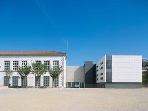 Un edifici escolar modern amb grans finestres i un pati espaiós.