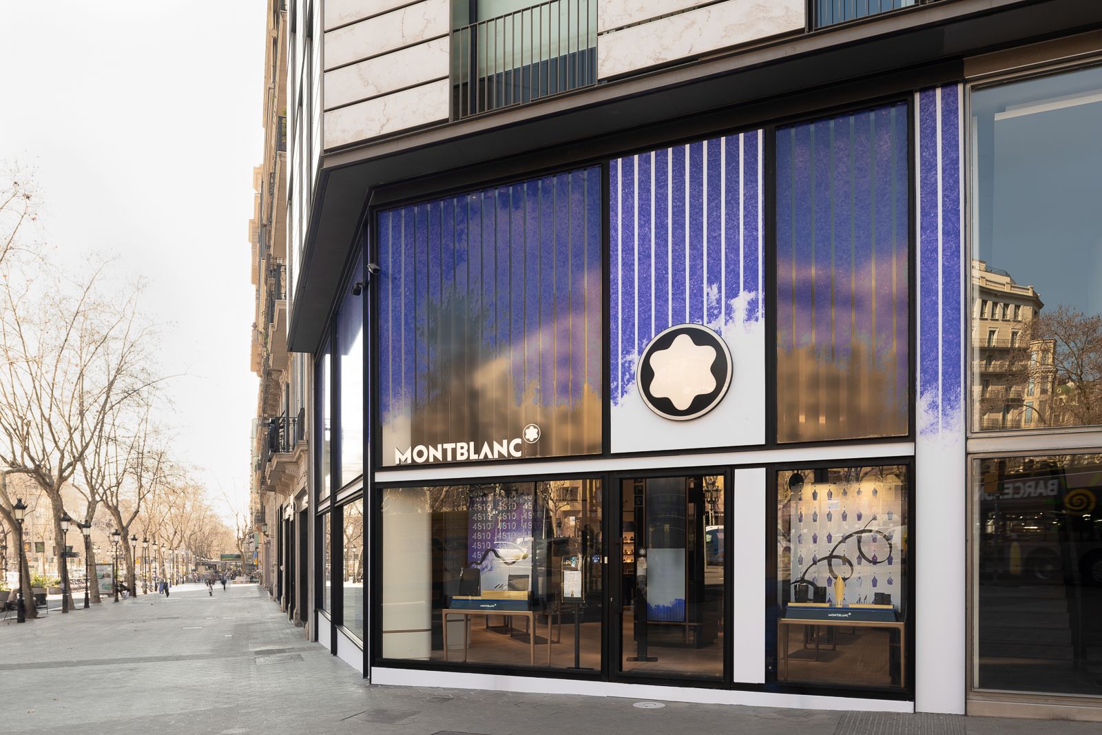 Exterior de tienda Montblanc en una calle tranquila con grandes ventanas, marca moderna y una fachada sofisticada.